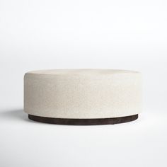 a white round ottoman sitting on top of a table