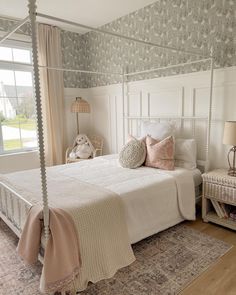 a white bed sitting in a bedroom next to a window with lots of light on it