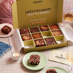 an assortment of desserts and drinks on a table next to a woman holding a glass of wine