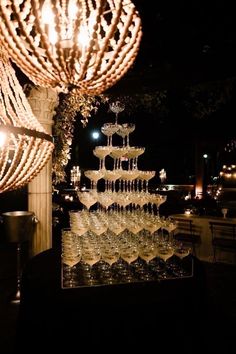 a table with many wine glasses on it and a chandelier hanging from the ceiling