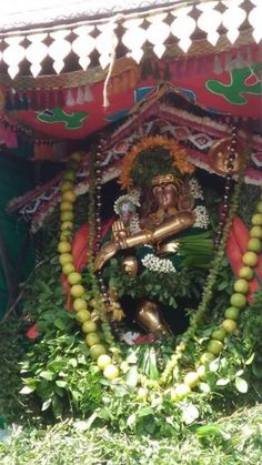 the statue is surrounded by greenery and flowers