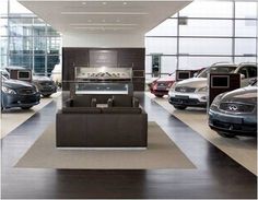 a car showroom with several cars parked in the lot and an oven on the wall