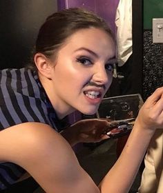 a woman taking a selfie in front of a mirror