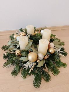 a christmas wreath with candles and greenery