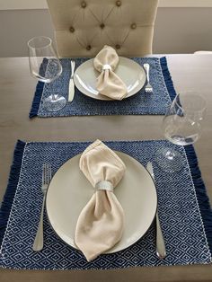 the place setting is ready to be served for two people, including one with a napkin on it