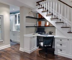 an open concept home office with stairs leading up to the second floor and desk area