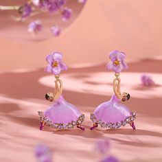 Convey your love of ballet and dance with these ballerina earrings fashioned from sterling silver and multi-colored enamel. The prima ballerina is adorned with a purple enamel tutu, embroidered with sparkling purple stones. She will delight those who want to profess their love of ballet. Your little ballerina will fall in love with these ballet dancer earrings.Carat Weight: 2.27 ctStone Size: 2 mmNumber of Stones: 24 Stone Color: Citrine Yellow, Amethyst PurpleStone Shape: RoundWeight: 4.47 gWid Whimsical Purple Earrings, Dancesport Jewelry, Dream It Possible, Ballet Earrings, Ballerina Earrings, Whimsical Purple Flower-shaped Jewelry, Ballerina Necklace, Ballerina Jewelry, Dreamy Garden