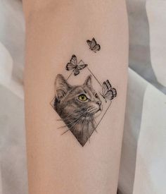 a cat and butterflies tattoo on the arm