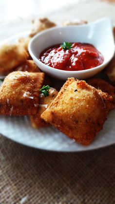 a white plate topped with fried food and dipping sauce