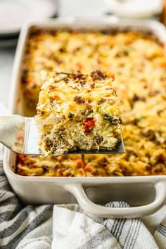 a spatula is holding up a slice of casserole