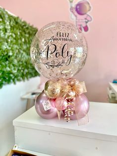 a pink and gold balloon sitting on top of a table