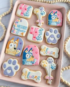 decorated cookies in the shape of animals on a pink tray