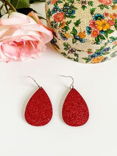 The classic teardrop earring is stunning in red glitter leather! These beauties sparkle like rubies, but are lightweight genuine leather! This glitter is so pretty and doesn't shed! Grab this sparkly pair now for the holidays, then wear year-round! Stainless steel ear hooks. Teardrop Earrings For Valentine's Day Party, Red Glitter Earrings For Party, Glitter Teardrop Earrings As Gift, Glitter Teardrop Earrings For Gifts, Red Glitter Party Earrings, Holiday Party Earrings, Stocking Stuffers For Women, Bling Earrings, Western Earrings