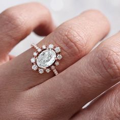 a woman's hand with a diamond ring on top of her finger and an engagement band