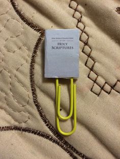 a yellow paper clip on top of a bed