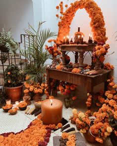 an arrangement of flowers and candles in front of a table with a mirror on it