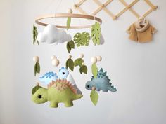 a crib mobile with dinosaurs hanging from it's sides