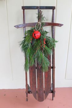 a wooden sled with christmas decorations hanging from it