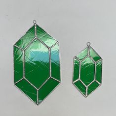 two green stained glass pendants sitting on top of a table