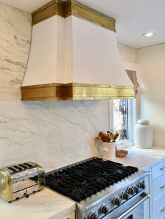 a stove top oven sitting inside of a kitchen next to a wall mounted range hood