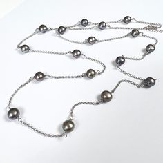 Freshwater Pearl Silver Chain Station Necklace 32" **Handmade : The necklace was made up of 17 pieces of Grey Cultured Freshwater Pearl with each piece wire-wrapped by sterling silver wire by hand. **Due to the organic nature of pearls, there is some minor difference in shape and color of each piece of pearl. Materials : Pearl : Top quality Grey Freshwater Pearl of size 7-8mm 17 pieces Chain & Wire : Sterling silver with white gold plated Clasp : Sterling Silver Spring Ring clasp Length : 32" Pa Silver Pearl Beaded Long Necklace, Silver Wire Wrapped Lariat Necklaces, Silver Long Necklace With Pearl Chain As Gift, Silver Long Necklace With Pearl Chain For Gift, Silver Round Beads Necklace For Gift, Elegant Silver Wire Wrapped Lariat Necklace, Elegant Silver Wire Wrapped Chain Necklace, Silver Single Strand Tahitian Pearl Necklace, Silver Beaded Chain Necklace For Gift