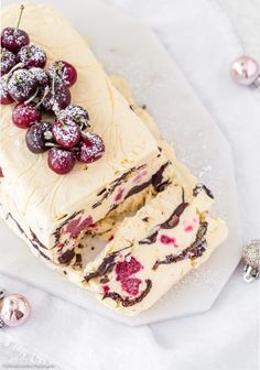 a piece of cake with berries on it sitting on top of a white table cloth