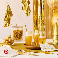 a table topped with drinks and gold decorations