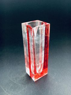 a red glass vase sitting on top of a table