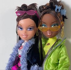 two dolls are posed next to each other with sunglasses on their heads and hair in pony tails