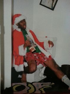 a man dressed as santa clause sitting on a toilet