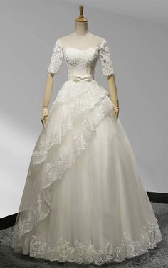 a white wedding dress on display in a room