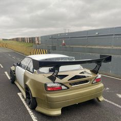 the car is parked on the side of the road with its surfboard strapped to it's roof