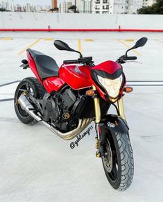 a red and black motorcycle parked in a parking lot