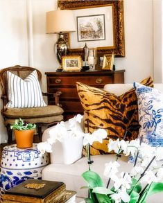 a living room filled with lots of furniture and flowers on top of a white couch