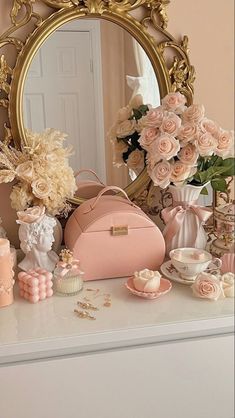 a vanity with flowers, cupcakes and a mirror