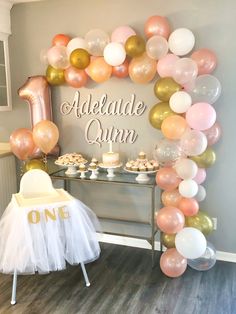 a table with balloons, cake and cupcakes in front of the sign that says aldelande ann