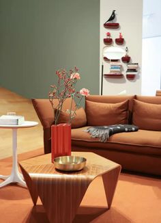 a living room with a couch, table and vase filled with flowers on the coffee table