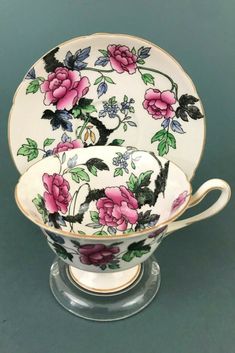 an antique tea cup and saucer decorated with pink flowers