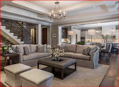 a living room filled with lots of furniture and a chandelier hanging from the ceiling