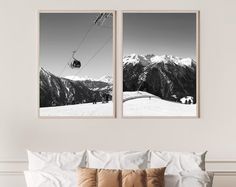 two black and white pictures hanging on the wall above a bed in front of a mountain view