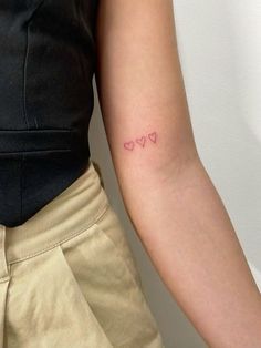 a woman's arm with two small hearts on the left side of her arm