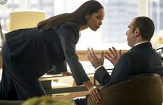 a man and woman sitting in an office chair talking to each other with their hands together