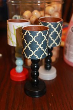 two black and white cups sitting on top of a wooden table next to other items