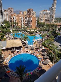 an aerial view of a large swimming pool in the middle of a city with tall buildings