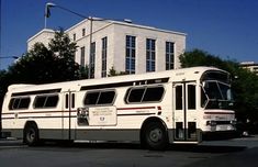 a white bus is parked in front of a building