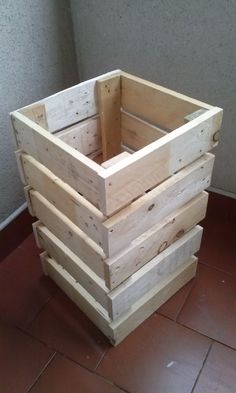 a stack of wooden crates sitting on top of a tile floor next to a wall