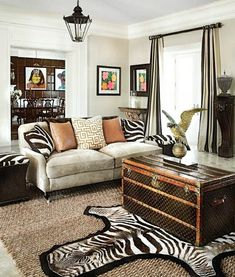 a living room filled with furniture and zebra rugs