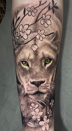 a lion with green eyes and flowers on his leg