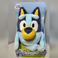 a blue and yellow stuffed animal in a box