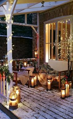 a patio covered in snow with lit candles